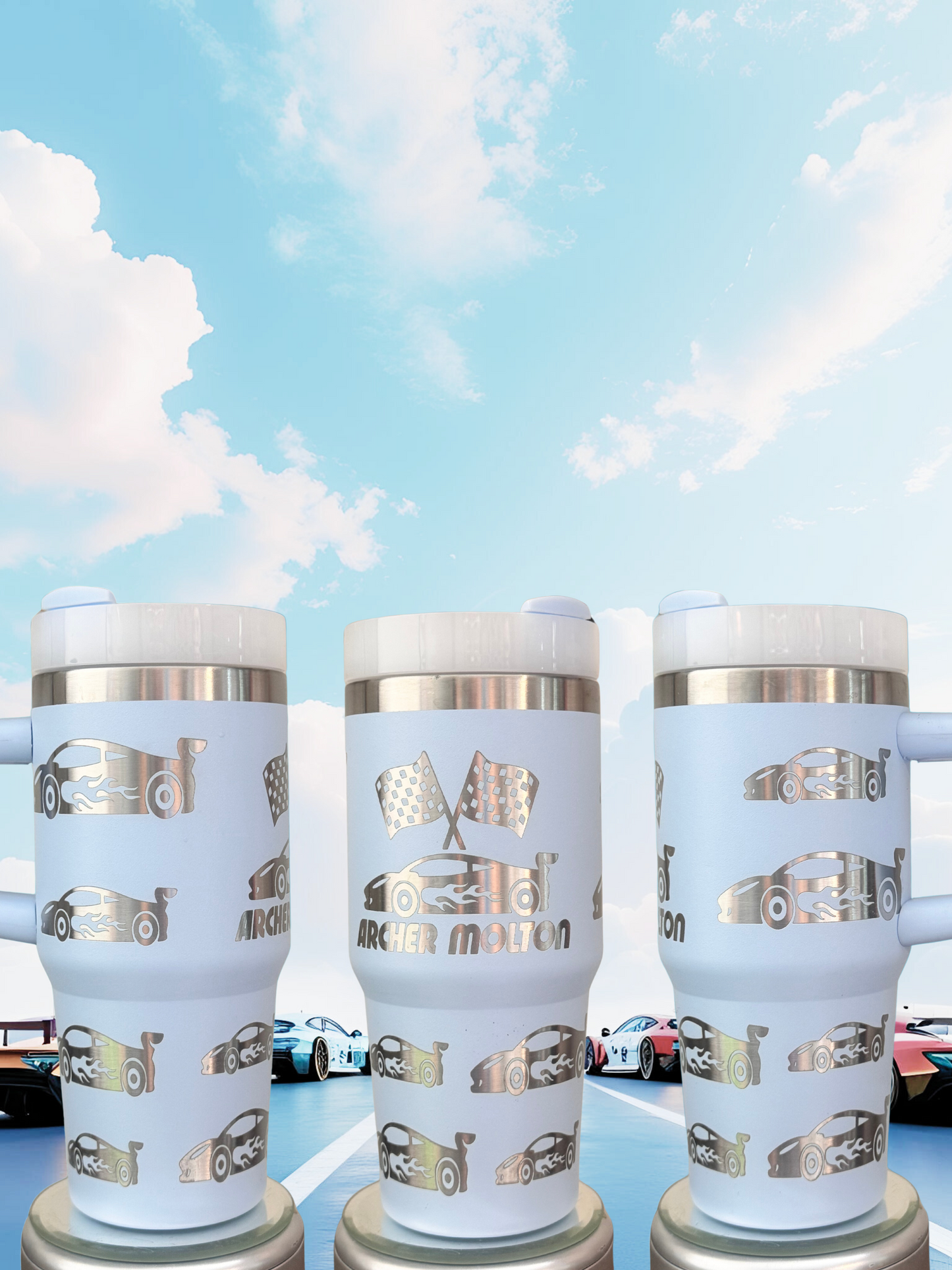 Three white tumblers with silver designs featuring racing cars on a blue background.