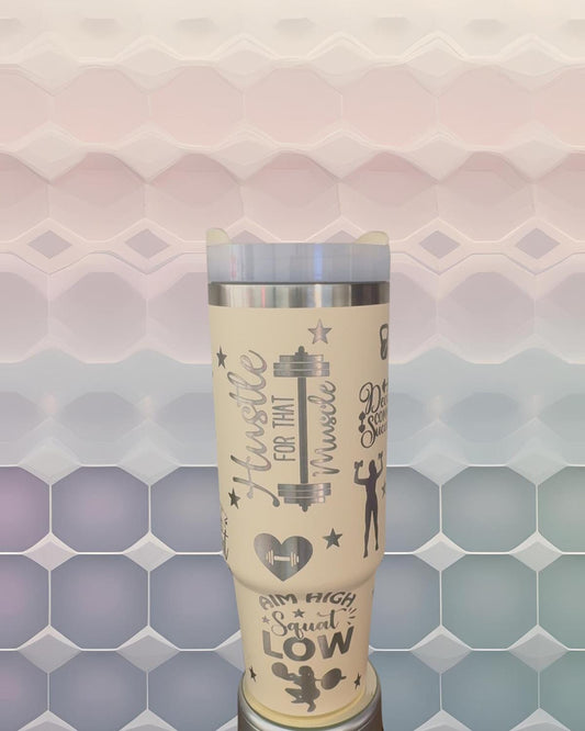 A beige insulated tumbler with various fitness-related text and graphics printed on it, including the words &quot;Hustle for that Muscle&quot; and &quot;I&#39;m High Squat Low&quot;.